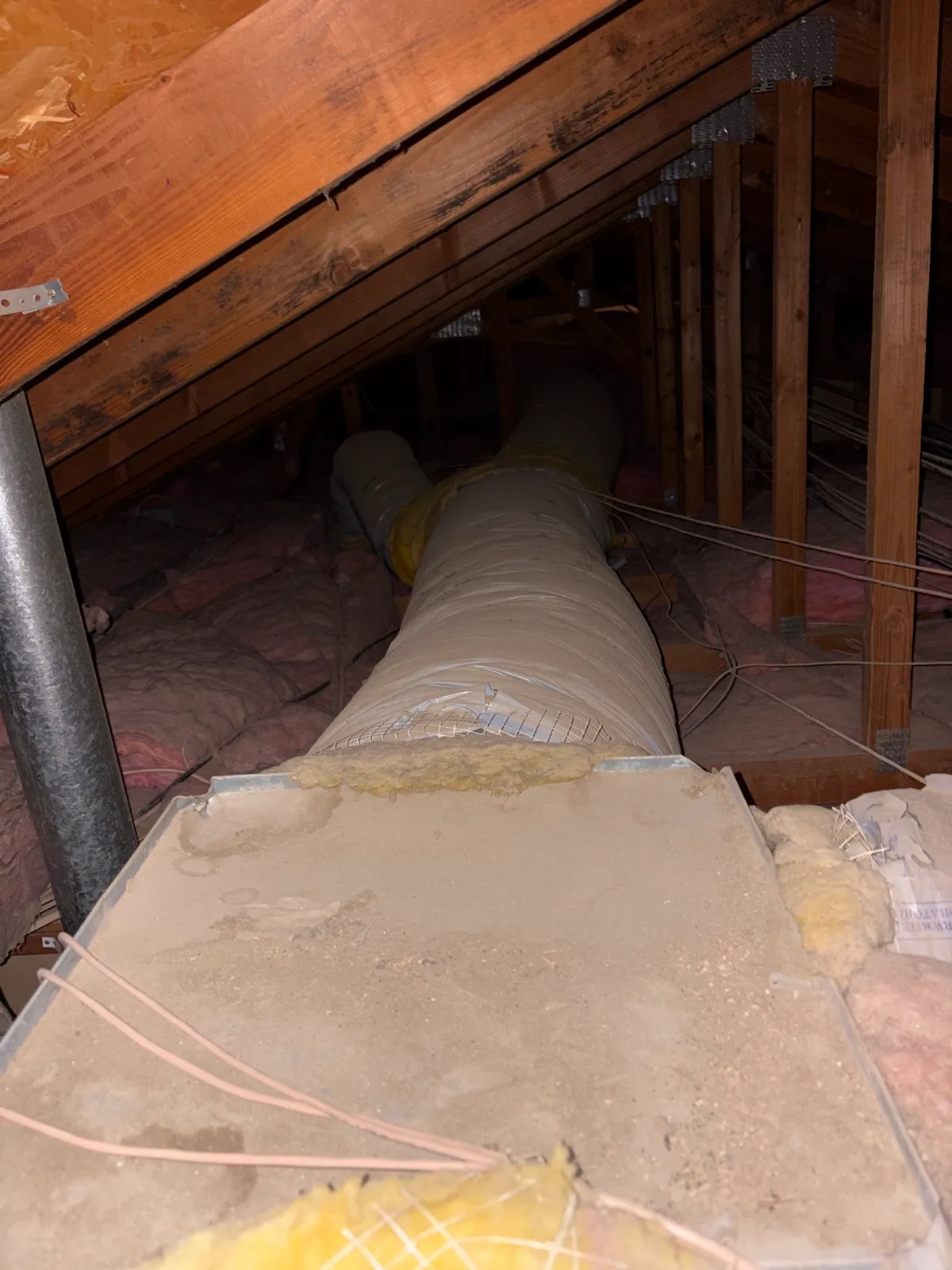 Old grimy round air duct in an attic before Abundant Air ductwork replacement in La Quinta CA