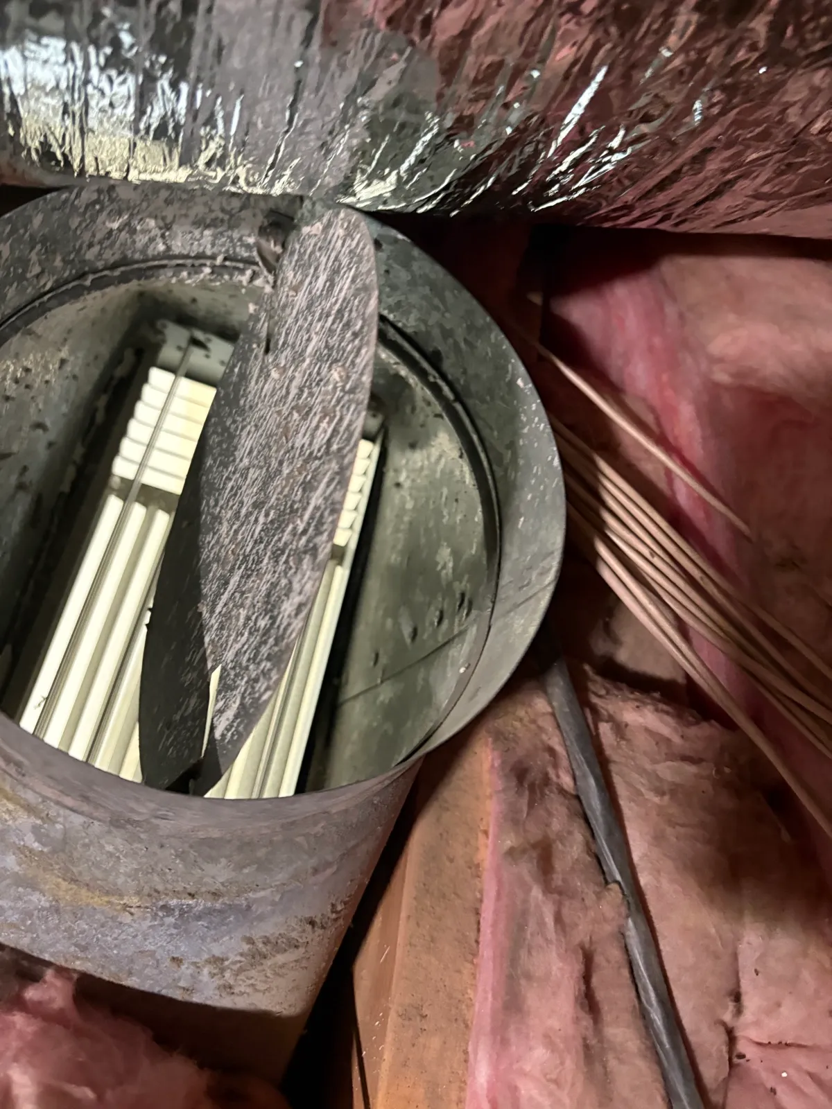 Torn metal duct boot leaking air into an attic before Abundant Air repair