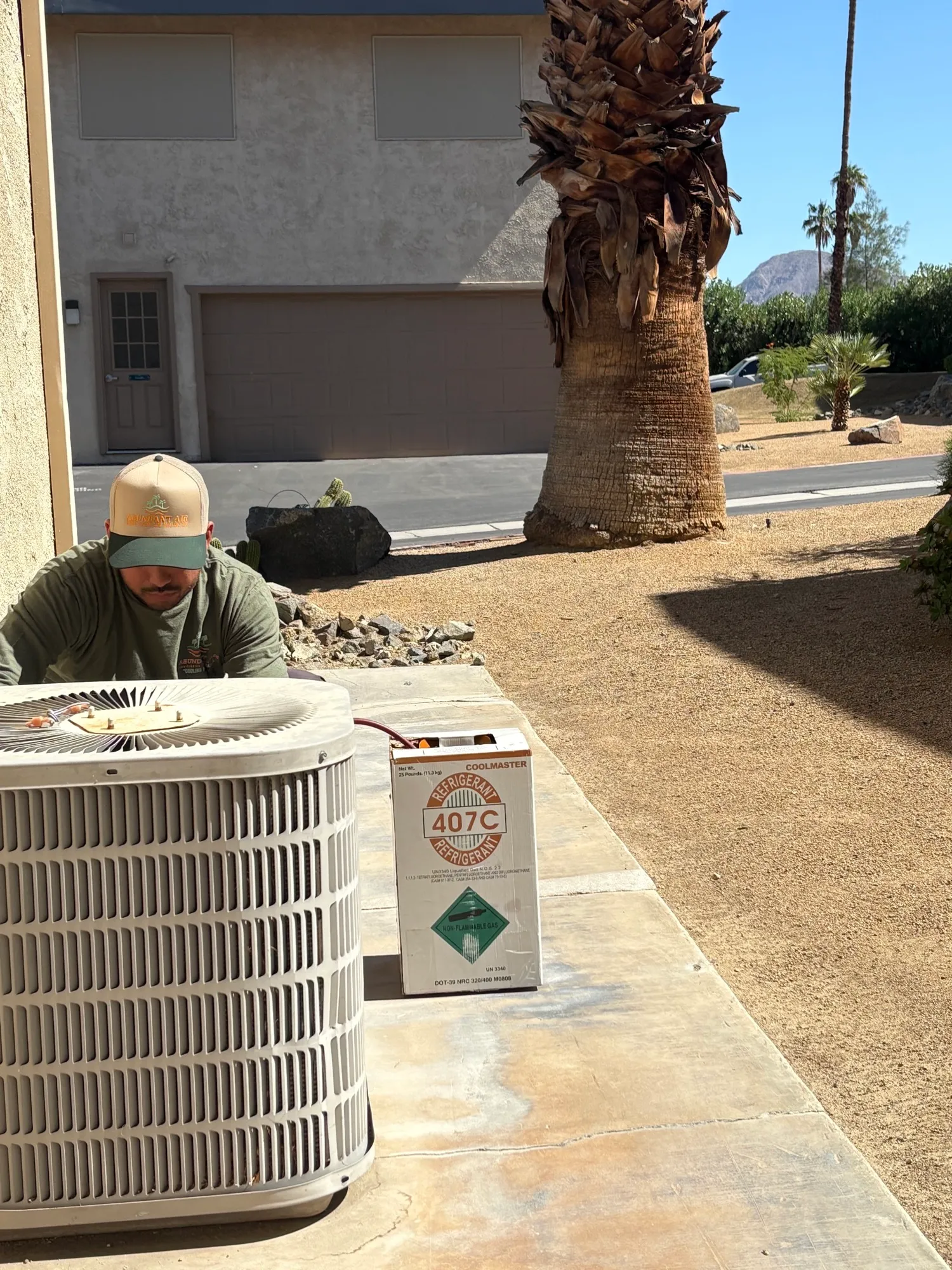 Abundant Air technician servicing outdoor condenser unit with R-407C